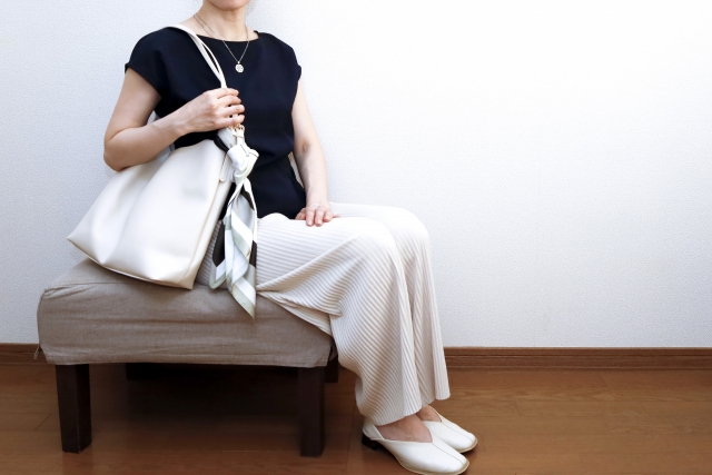 スカーフを巻いたバッグを持つ女性